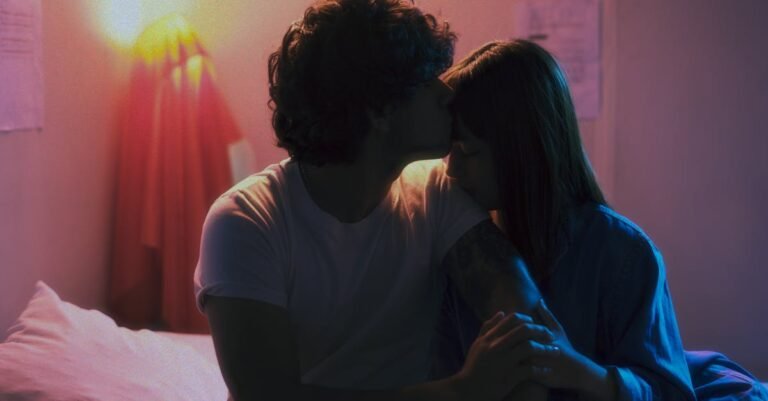 A young couple sharing a tender moment indoors with a warm, intimate ambiance.