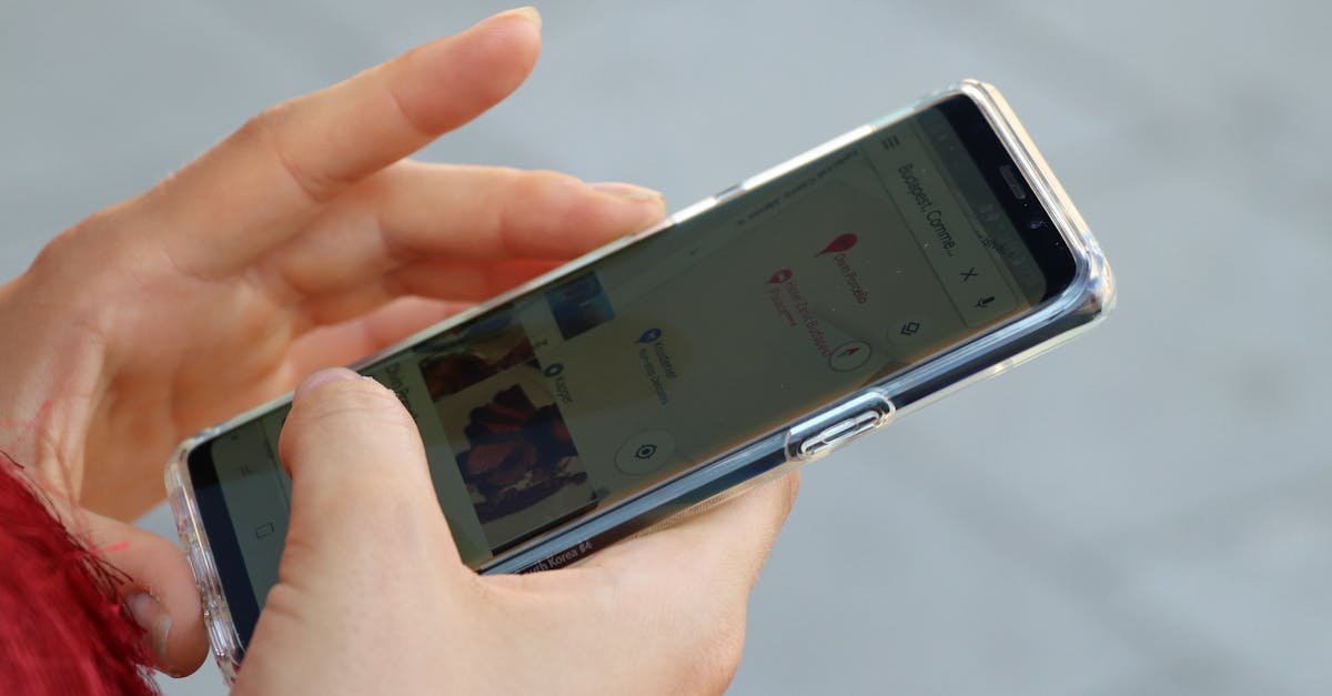 Hands holding a smartphone with a clear case, browsing a map outdoors.