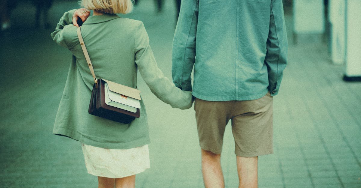 A fashionable couple walking hand in hand in a stylish urban setting.