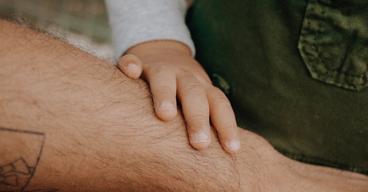 Close-up of a child's hand gently touching an adult's forearm, symbolizing connection.