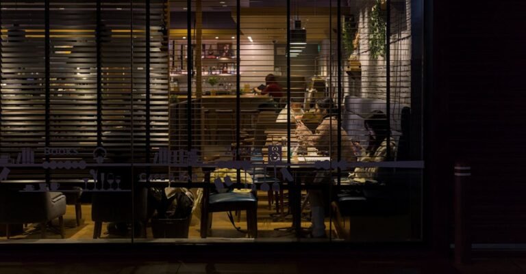 Nighttime view of a cozy Kyoto café illuminated with soft lighting, capturing a warm and inviting urban atmosphere.