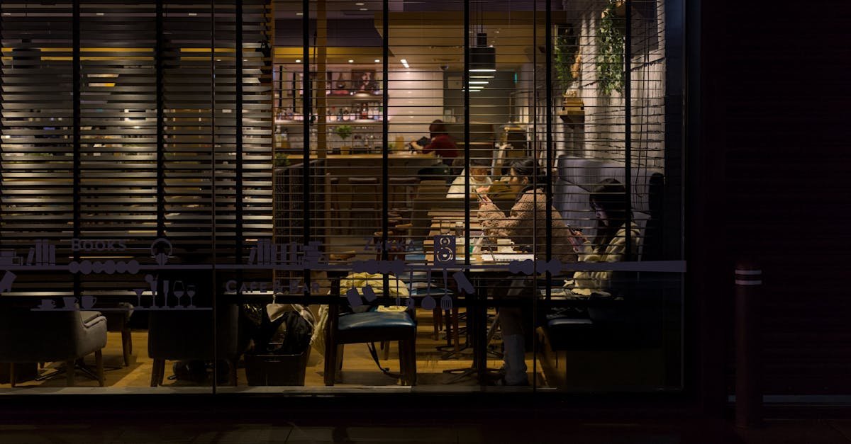 Nighttime view of a cozy Kyoto café illuminated with soft lighting, capturing a warm and inviting urban atmosphere.