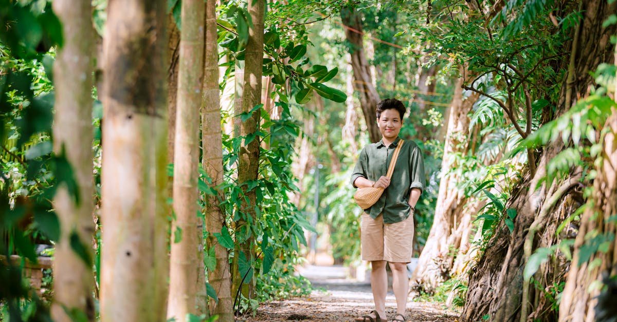 Person enjoys a serene walk through a sunny, lush green forest pathway. Vibrant summer scene.