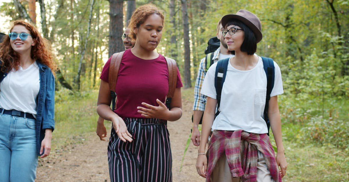 A diverse group of young adults hiking through a lush forest, enjoying their outdoor adventure.