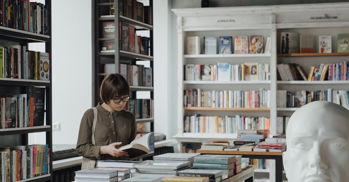 A woman browses books in a modern, well-lit bookshop surrounded by shelves.