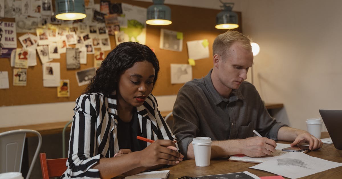 Coworkers collaborating in a creative office space, working on design projects with focused attention.