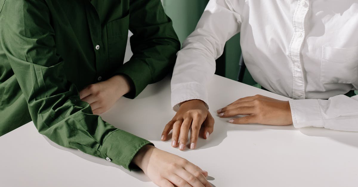 A close-up of diverse hands resting on a white table, showcasing unity and connection.