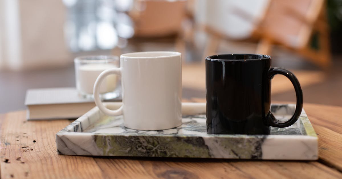 A stylish set of black and white coffee mugs on a marble tray, perfect for contemporary interiors.