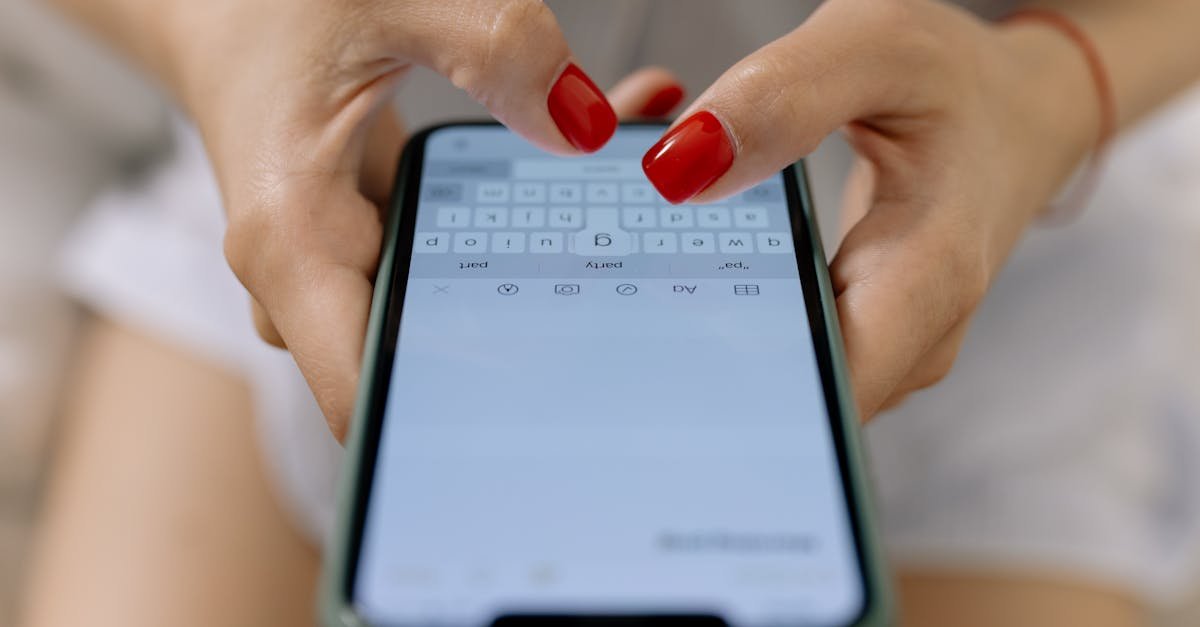 Close-up image of hands with red nails typing on a smartphone screen, showcasing modern technology.