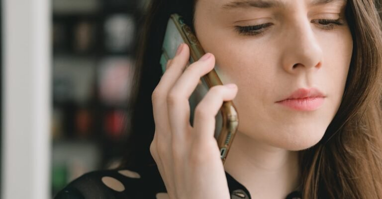 Close-up of a woman engaged in a phone conversation indoors, depicting a thoughtful expression.