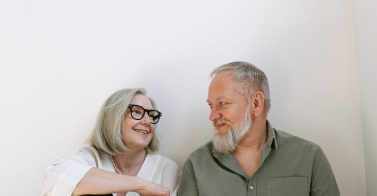 An elderly couple sharing a loving moment with smiles indoors.