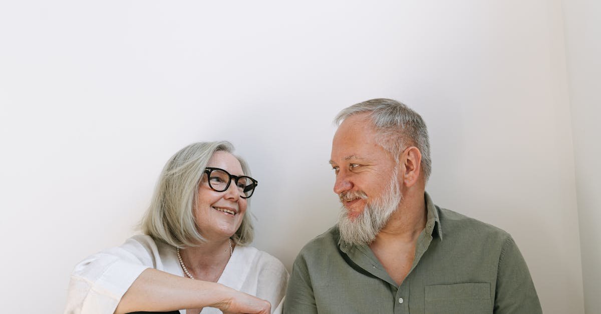 An elderly couple sharing a loving moment with smiles indoors.