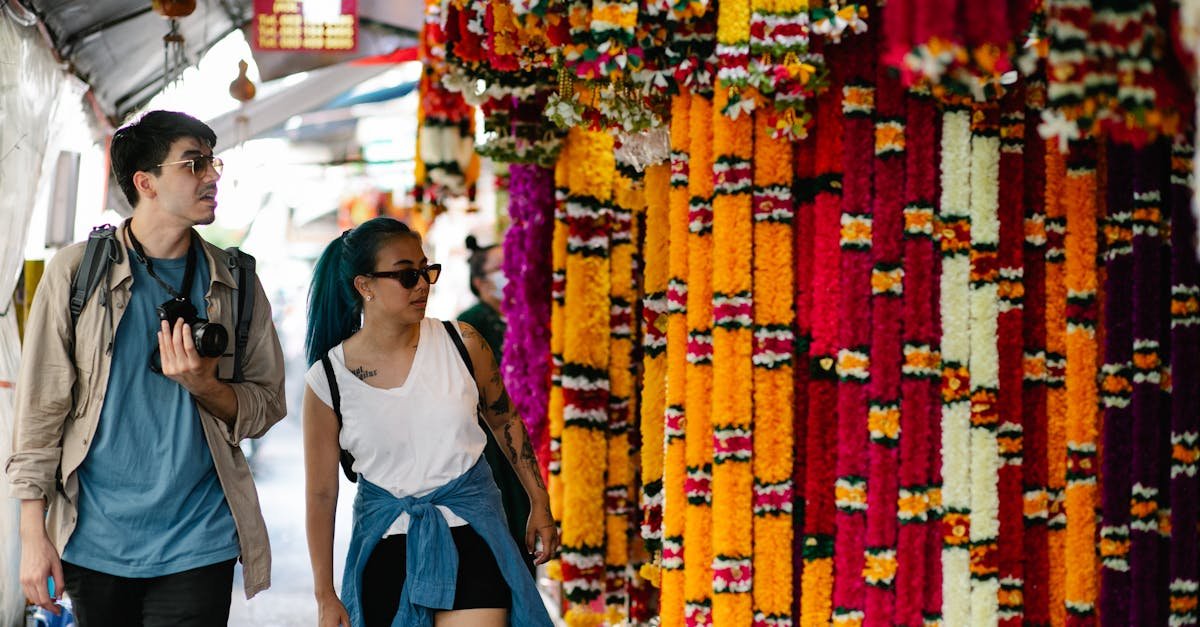 A man and woman walk through a colorful flower market, capturing vibrant cultural scenes.