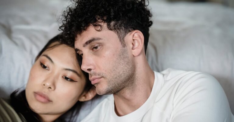A couple sitting together, sharing a quiet, contemplative moment indoors.