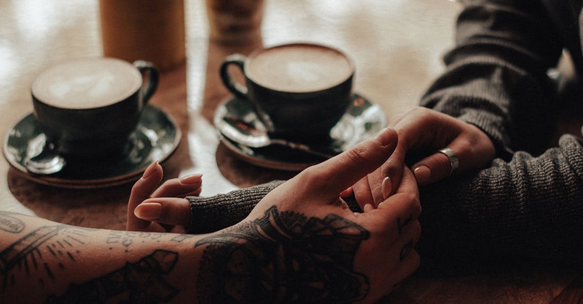 A couple holding hands over coffee in a cozy café setting, expressing love and connection.