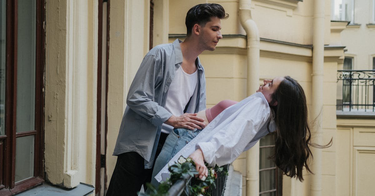 Young couple sharing a joyful moment on a balcony, capturing urban romance.